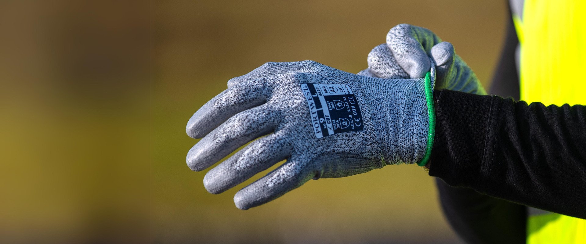 one hand in a working glove over a blurred background